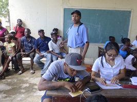 Thera working with translator Junior and Dr. Joey Prosper in the background